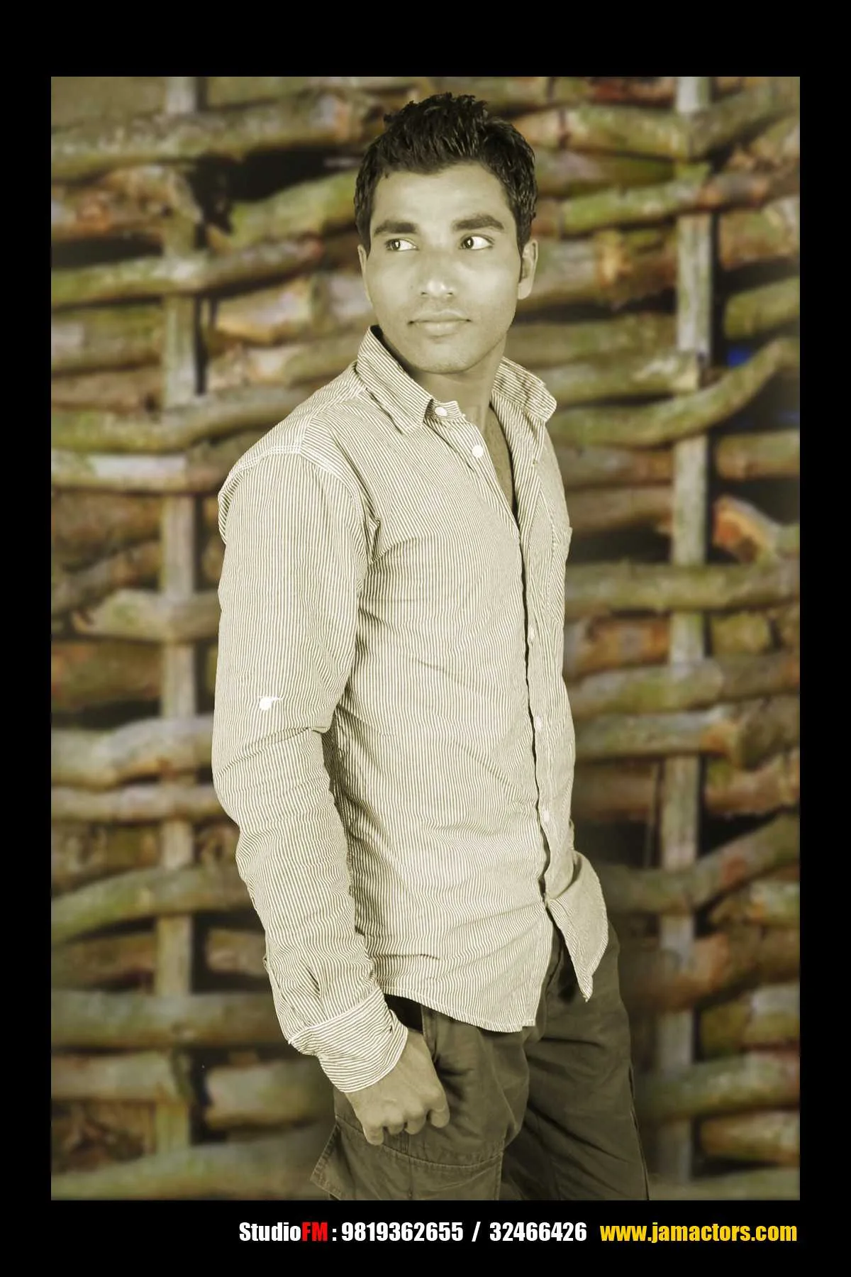 Young man in a casual outfit posing confidently against a wooden backdrop